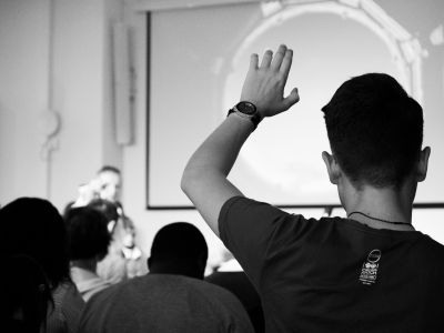 a student raising his hand in the classroom