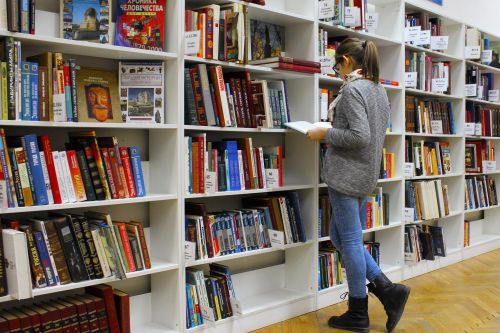 photo of a woman in front of a row of bookshelves