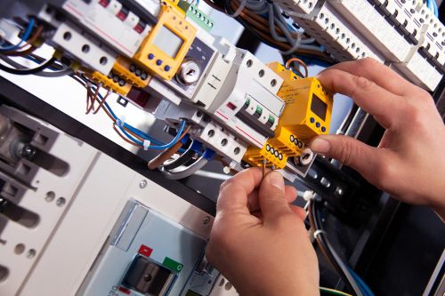 close up photo of hands and an electrical board