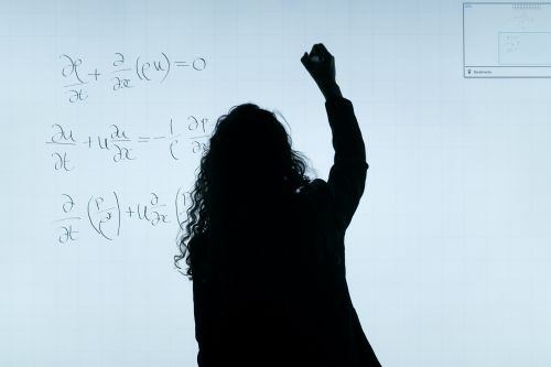 photo of a silhouette against a board covered with math problems