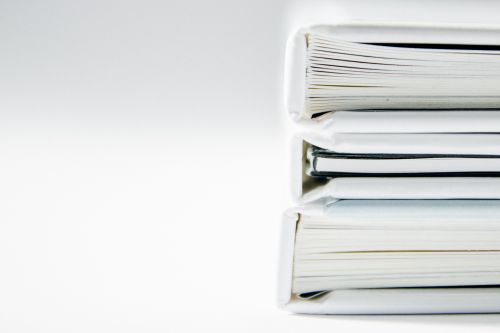 photo of several white books stacked on top of each other