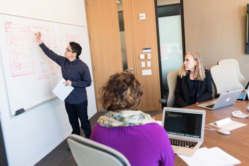 photo of several people in a conference room having a discussion