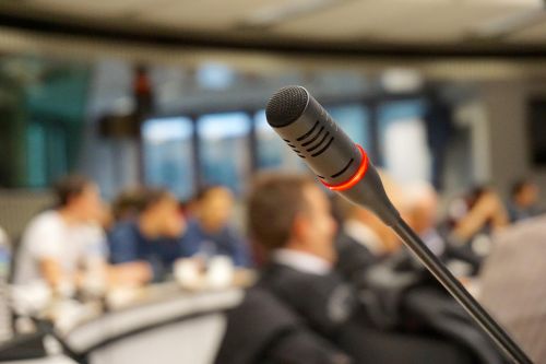 close up photo of a microphone with people in the background