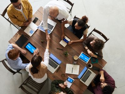 a group of people around a table with computers