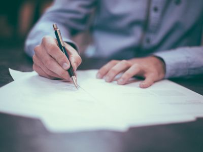 Photo of a man writing on papers