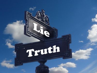 Image of sign pointing to truth one way and lie another way.