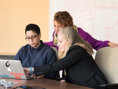 three people looking at a computer