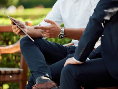 two businessmen in a park having a conversation