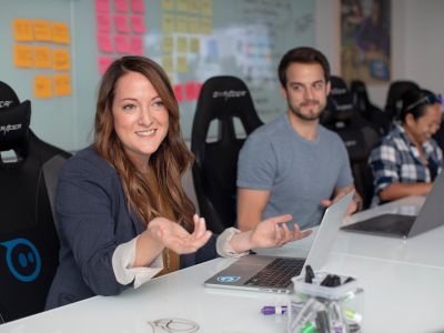 a woman speaking with a team of co-workers