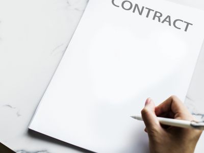 Image of a person signing a contract.