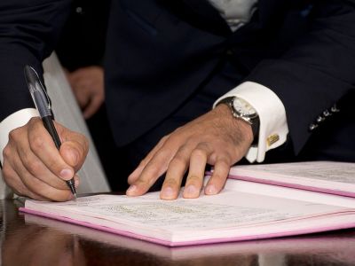 Photo of businessman signing documents.