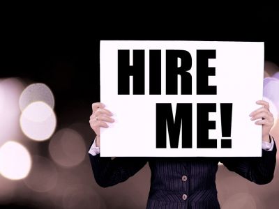 Image of job candidate with hire me sign.