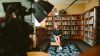 photo of a woman in front of bookshelves with a bright light in front of her